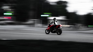 Kırmızı motosiklet. Hareket halinde. En az kablolama ile fotoğraf. Sanatsal bir aygıt olarak küçük bir bulanık fotoğraf. Hız. Adrenalin. Moto