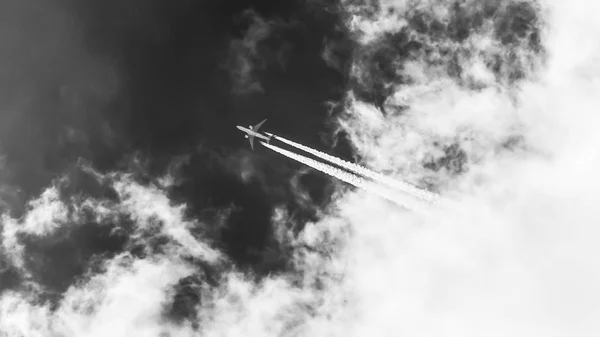 雲から飛ぶ飛行機 飛行機雲 旅行のテーマ モノクロ写真 — ストック写真