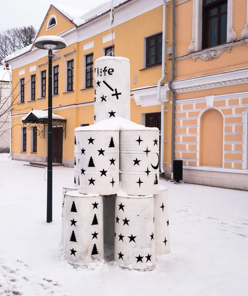 A festive public space. Christmas and new year tree made of metal barrels. Designer find. Carved in barrels elements-stars, Crescent and other decorative elements.