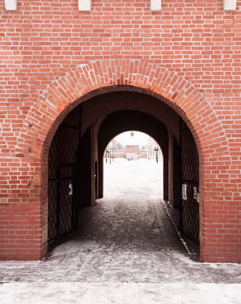 Light at the end of the tunnel. A view of the arch of the Kremlin. Brick walls of the Kremlin and the entrance gate in the form of an arch. White light on the other side of the arch. City attraction. Hiking trails, public spaces