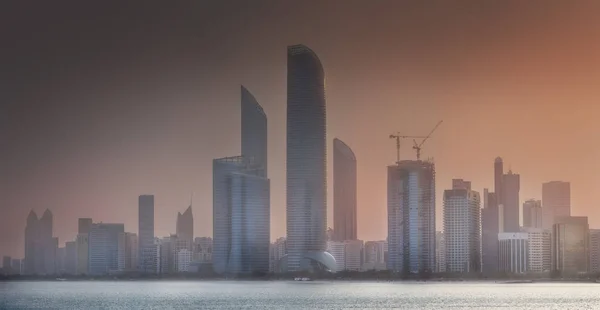Veduta di Abu Dhabi Skyline all'alba nebbiosa, Emirati Arabi Uniti — Foto Stock