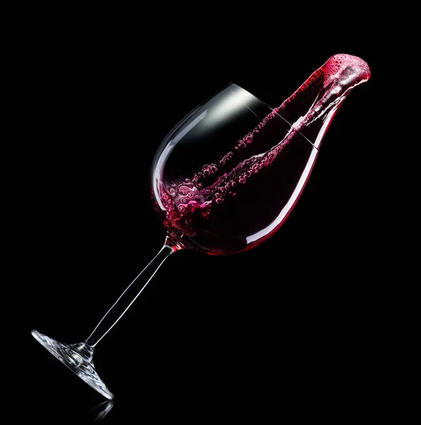 Sklo pro červené víno s potřísnění izolované na černém pozadí. — Stock fotografie