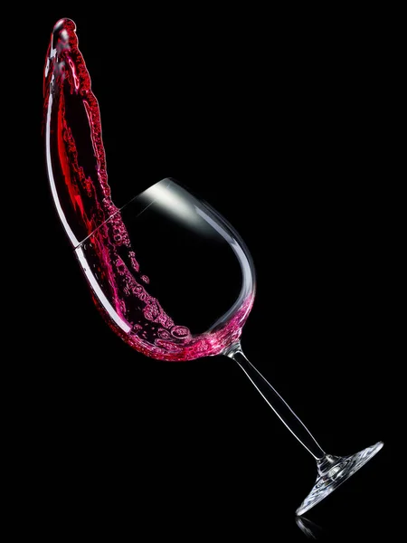 Bicchiere per vino rosso con spruzzi isolati su fondo nero . — Foto Stock
