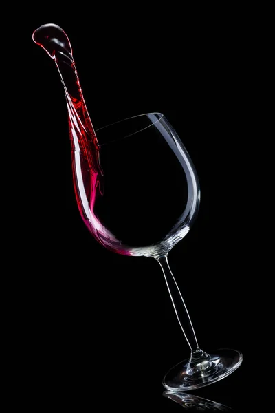 Glass for red wine with splashes isolated on black background. — Stock Photo, Image