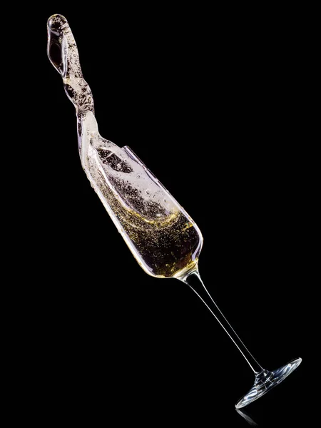 Glass for champagne with bubbles and splashes isolated on black background. — Stock Photo, Image