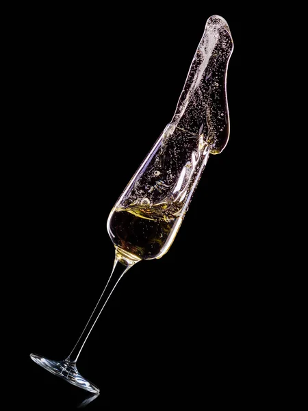Copa para champán con burbujas y salpicaduras aisladas sobre fondo negro . — Foto de Stock