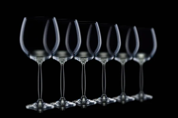 Set de vasos vacíos para vino tinto en fila aislados sobre fondo negro . — Foto de Stock