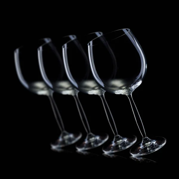 Set of empty glasses for red wine in a row isolated on black background. — Stock Photo, Image