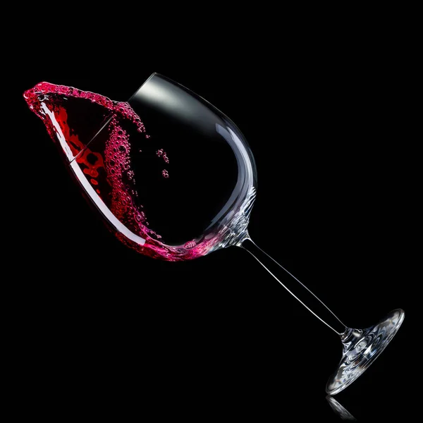 Szkło do czerwonego wina z rozpryskami wyizolowanymi na czarnym tle. — Zdjęcie stockowe
