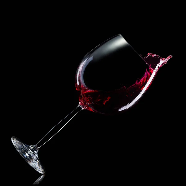 Copa para vino tinto con salpicaduras aisladas sobre fondo negro . — Foto de Stock