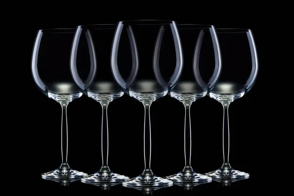 검은 색 배경에 고립 된 행에 레드 와인에 대한 빈 안경 세트. — 스톡 사진
