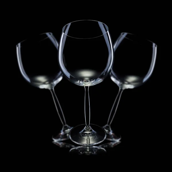 Ensemble de verres vides pour vin rouge dans une rangée isolé sur fond noir . — Photo