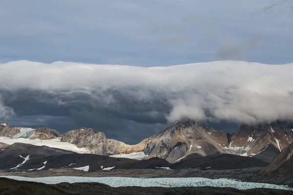 Foto Van Prachtige Rotsachtige Besneeuwde Bergen Met Lage Mooie Grijze — Stockfoto