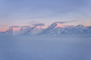 Karlı dağlarda Pastel renkli günbatımı