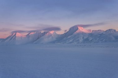 Karlı dağlarda Pastel renkli günbatımı