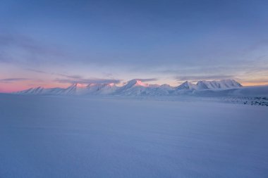 Karlı dağlarda Pastel renkli günbatımı