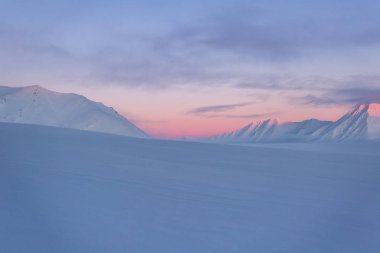 Karlı dağlarda Pastel renkli günbatımı