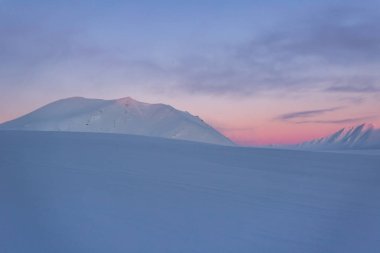 Karlı dağlarda Pastel renkli günbatımı
