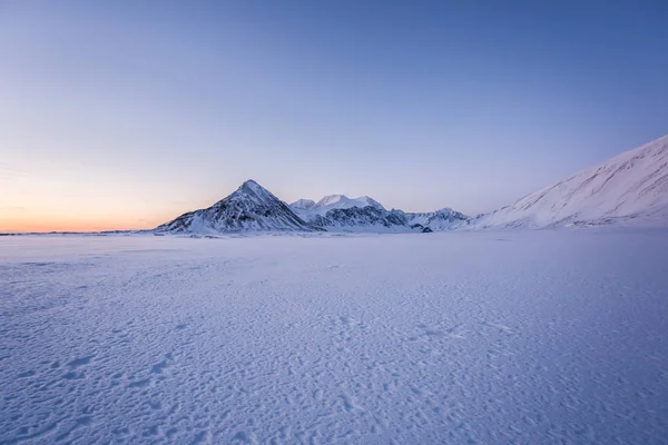 Bulutlu Karlı Bir Tepe Güzel Bir Günbatımı Manzaralı Fotoğraf — Stok fotoğraf