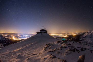 Karlı dağların üzerinde yıldızlı gökyüzü