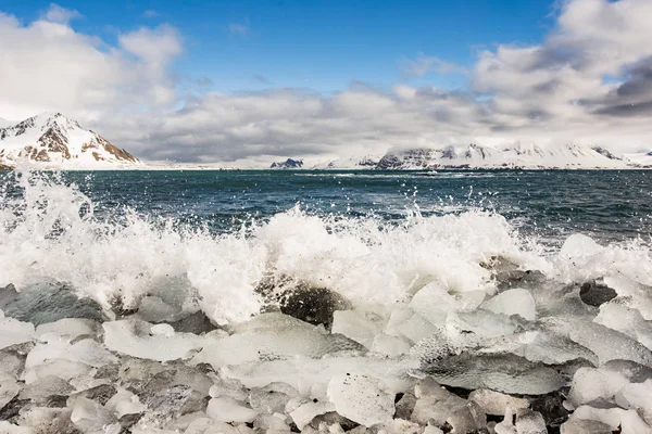Zimne Fale Morskie Rozpryskują Się Rozbitych Lodowych Skałach Brzegu — Zdjęcie stockowe