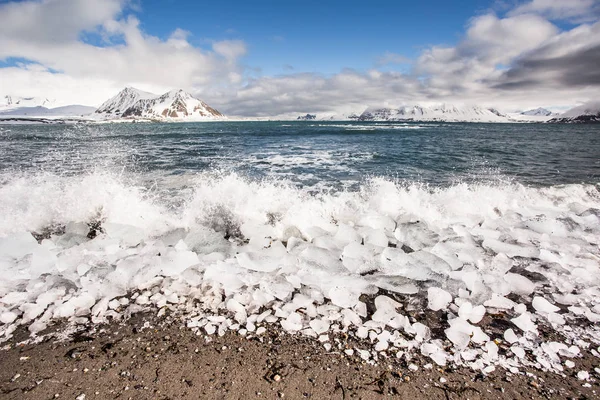 Soğuk Deniz Dalgaları Kıyıdaki Kırık Buz Kayaları Üzerine Sıçrıyor — Stok fotoğraf