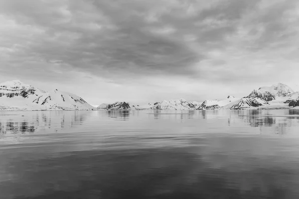 水から北極の雪の岩の多い山の海岸での眺め — ストック写真