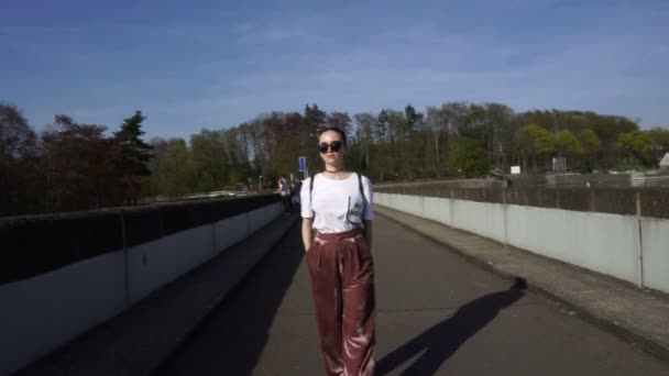 Trendy vrouw In velours broek lopen op brug — Stockvideo