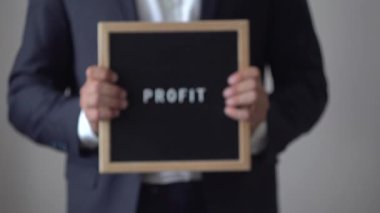 Mektup metin kurulu anonim işadamı elinde Word kar. Siyah ahşap mesaj panosu, iş kavramı holding arka plan bulanık, kameraya doğru gidiyor takım elbiseli adam, 4 k, kapatmak