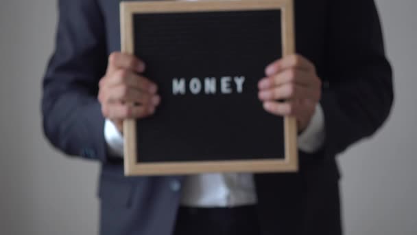 Деньги из писем на доске в руках бизнесмена — стоковое видео