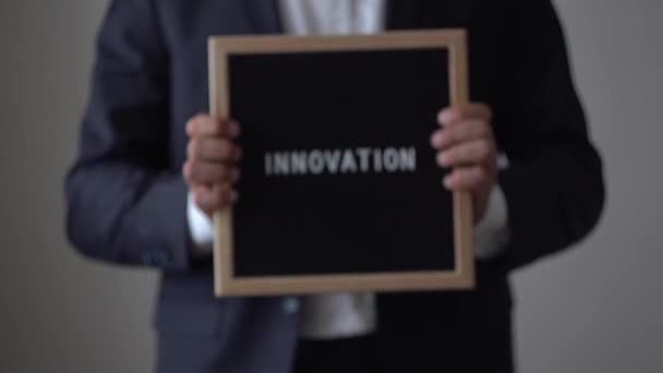 Wortinnovation aus Buchstaben auf Texttafel in anonymen Geschäftsmannshänden — Stockvideo