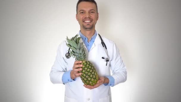 Médico que sostiene la piña orgánica natural, concepto sano de la nutrición de la vitamina — Vídeo de stock