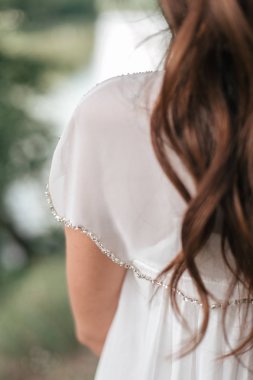 Beyaz gelinlik içinde genç kadın arkadan görünüş