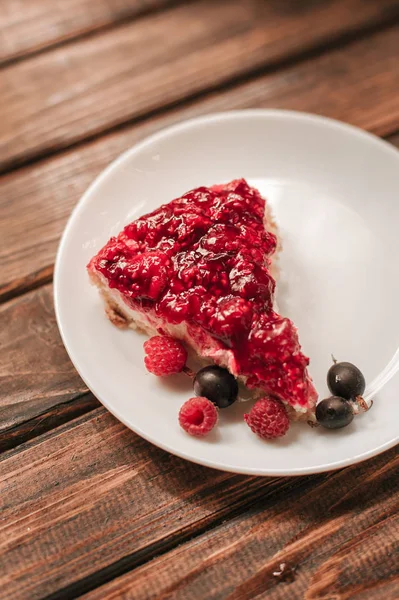 plate with piece of homemade sweet berry pie on wooden table, close-up