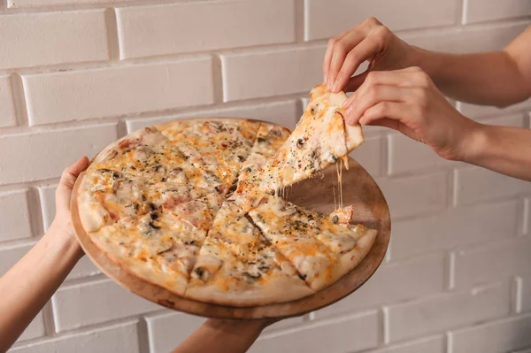 female hands taking piece of pizza, Close up view