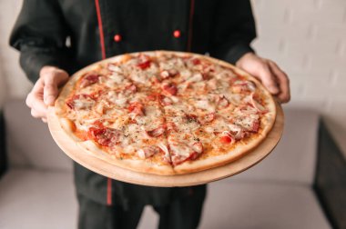 Lezzetli pizza elinde Şef görünümünü kapat