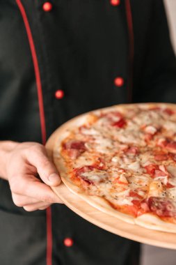 Lezzetli pizza elinde Şef görünümünü kapat
