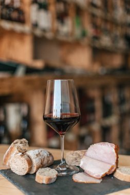 Ahşap masa üzerinde kırmızı şarap ile cam görünümü kadar kapatın