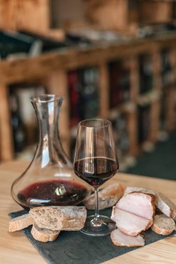 Ahşap masa üzerinde kırmızı şarap ile cam görünümü kadar kapatın