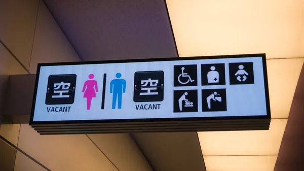 Airport toilet sign in Japanese, English, Chinese and Korean languages, together with icons of other facilities