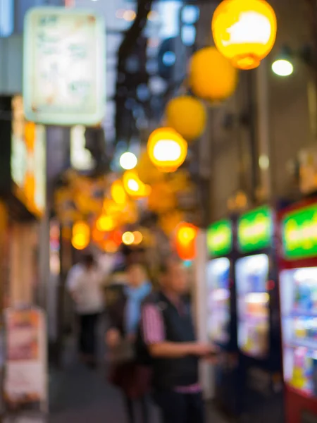 Blurred picture of people walking in the narrow backstreet of Yokochi Omoide.