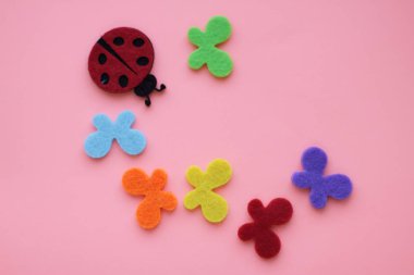 yapay wallowed yün uğur böceği ve mavi kırmızı yeşil turuncu kelebek pembe artalanları üzerinde sarı  