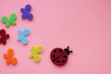 yapay wallowed yün uğur böceği ve mavi kırmızı yeşil turuncu kelebek pembe artalanları üzerinde sarı  