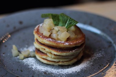 Nane ve elma ile sağlıklı kahvaltı için lezzetli taze pişmiş krep gri plaka reçel 