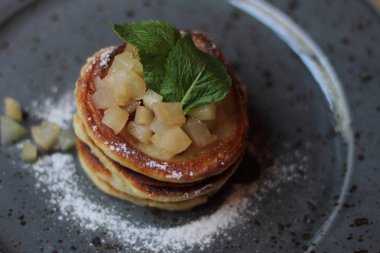 Nane ve elma ile sağlıklı kahvaltı için lezzetli taze pişmiş krep gri plaka reçel 