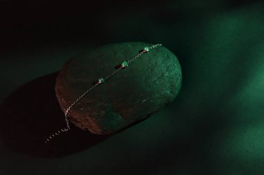 Siyah arka planda zümrüt lüks bilezik, yeşil taşlı gümüş mücevher.