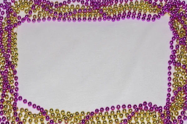 frame of beads for the holiday Mardi Gras with a background on a white fabric.