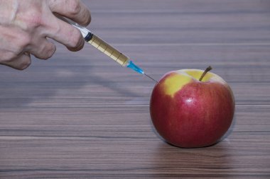 hangi bir şırınga, meyve gen modifikasyonu sembolü olarak eklenir bir elma.