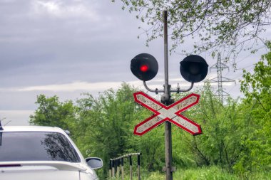Demiryolu geçişinde kırmızı semafor sinyali. Arabanın görünür kısmı.