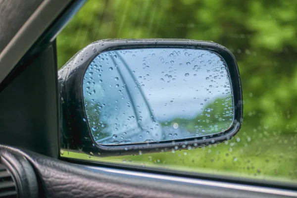 Rearview mirror. On the mirror there are drops of water after rain.